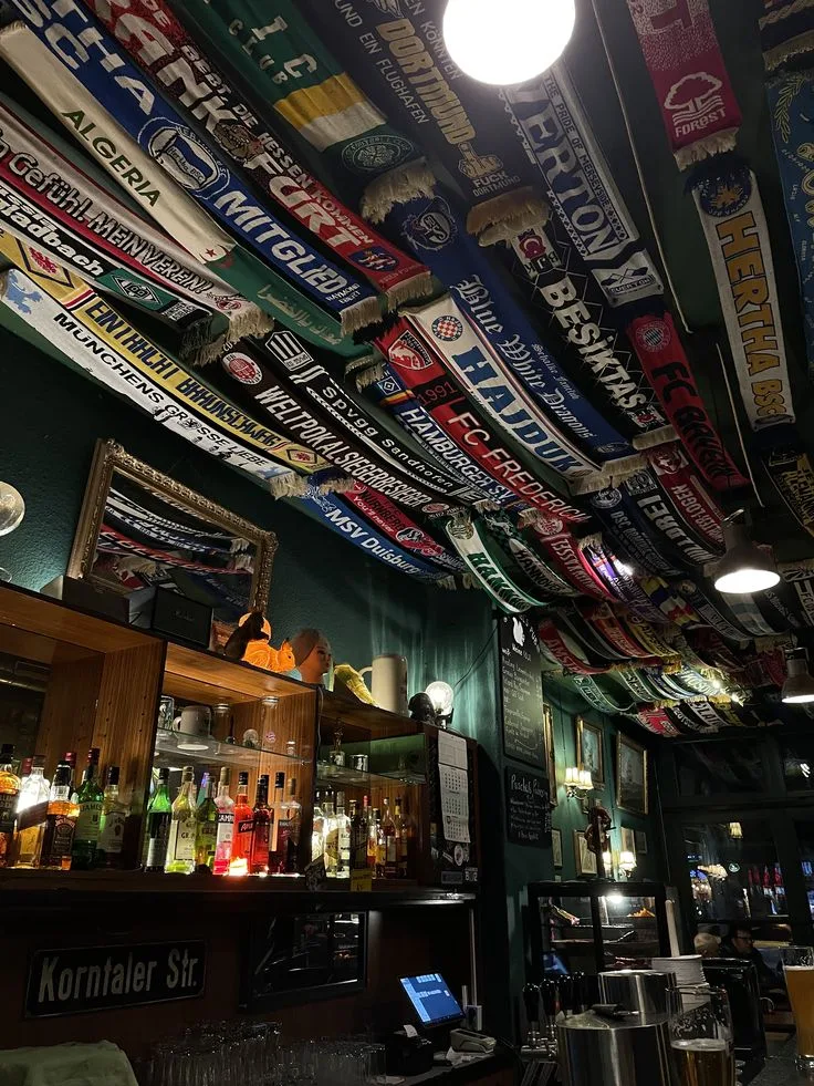 Plafond de pub tapissé d'écharpes de clubs du monde entier