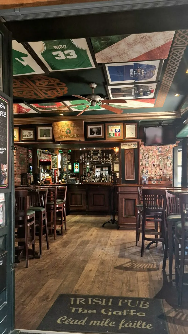 Pub en bois sombre avec maillots encadrés au plafond